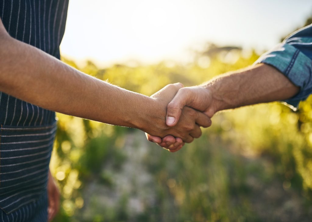 Cropped shot of a man and woman shaking hands on a farm